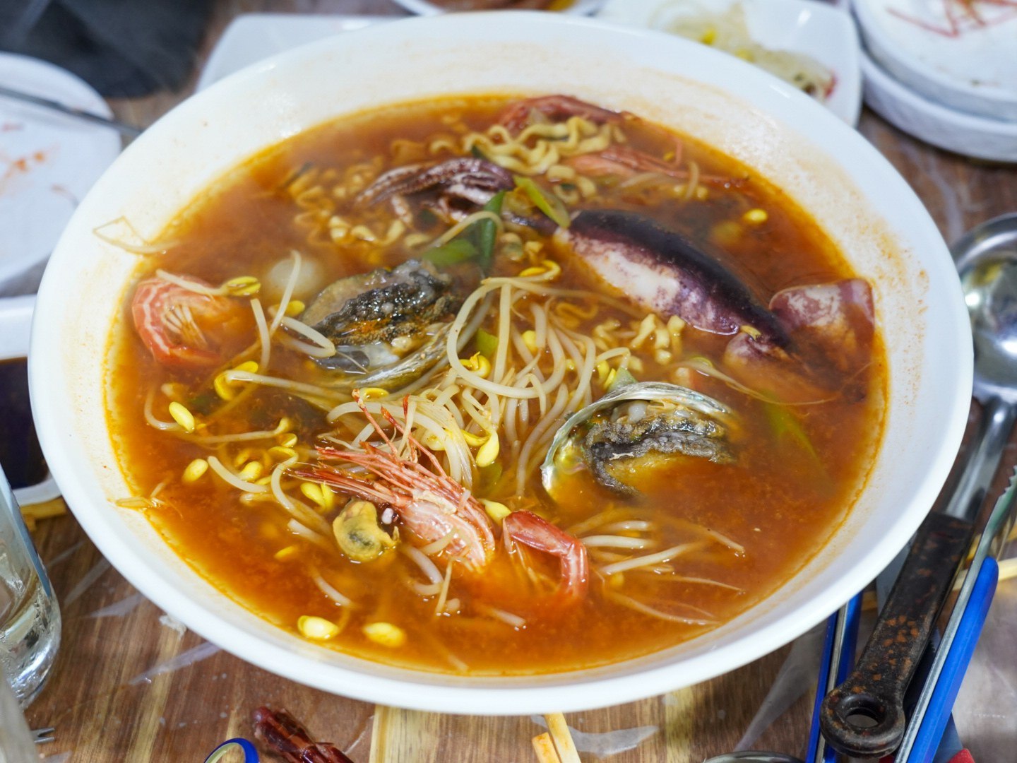 放了蝦、淡菜與豆芽菜的紅色海鮮拉麵