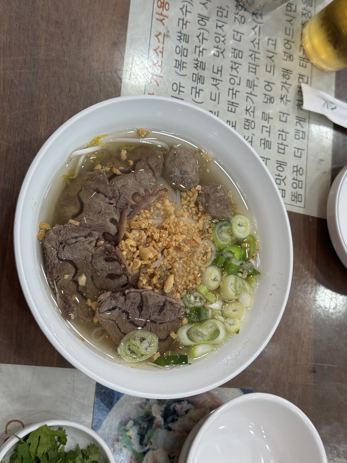Beef rice-noodle soup topped with fried garlic and spring onion