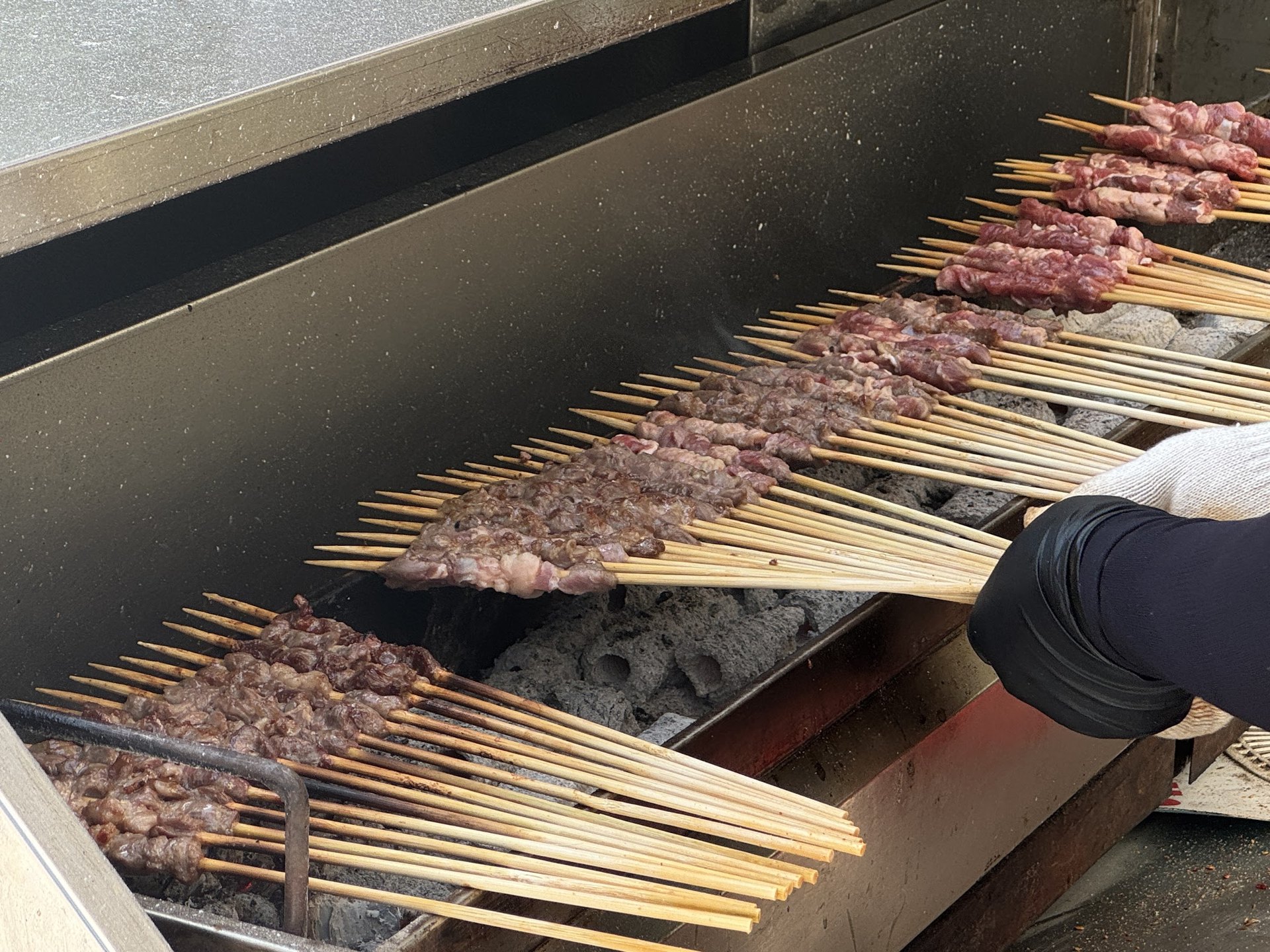 Lamb skewers lined up over a charcoal grill
