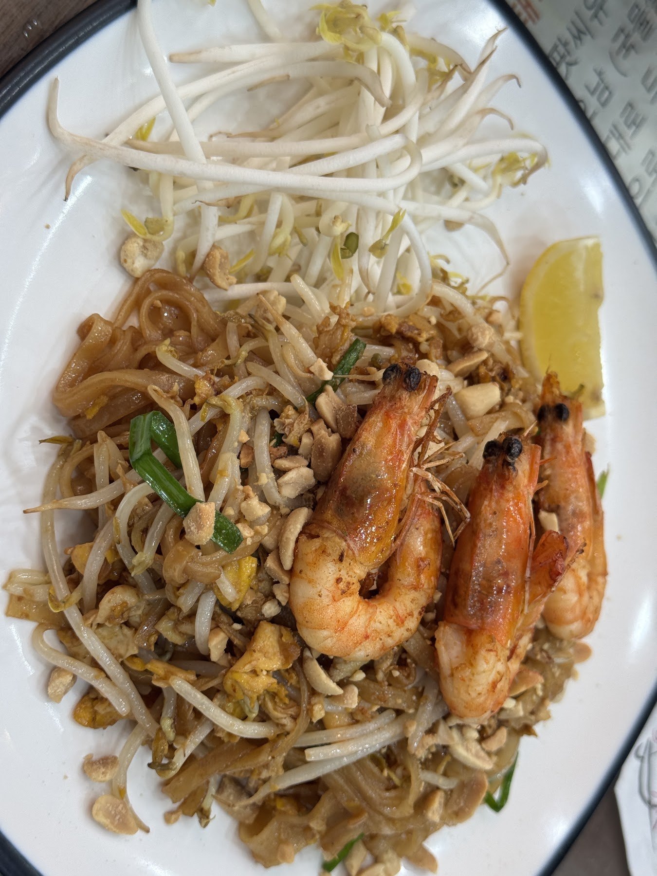 Pad thai topped with bean sprouts and prawns