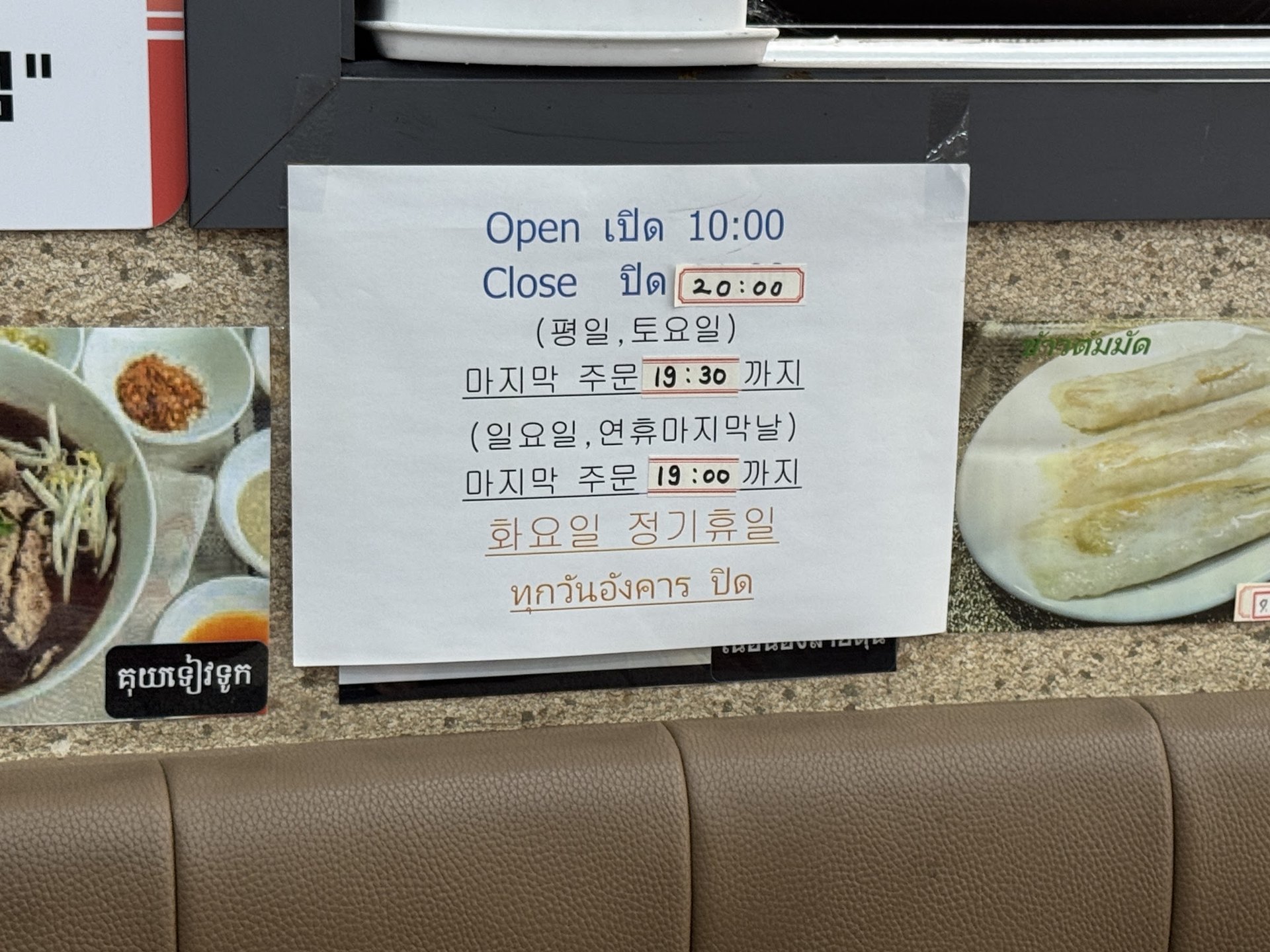 An opening hours notice written in both Korean and Thai