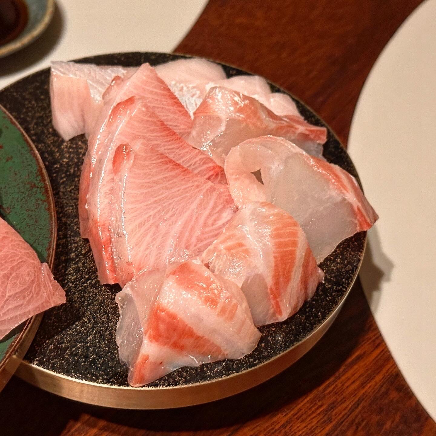 Sashimi of red and white fish mixed on a stone plate