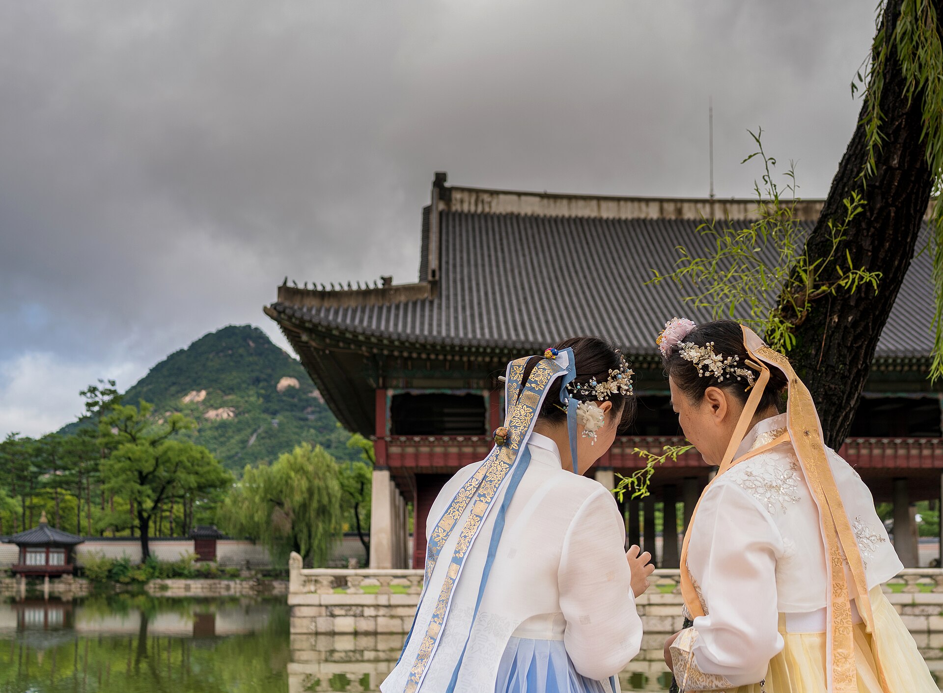 People in hanbok taking photos at a palace