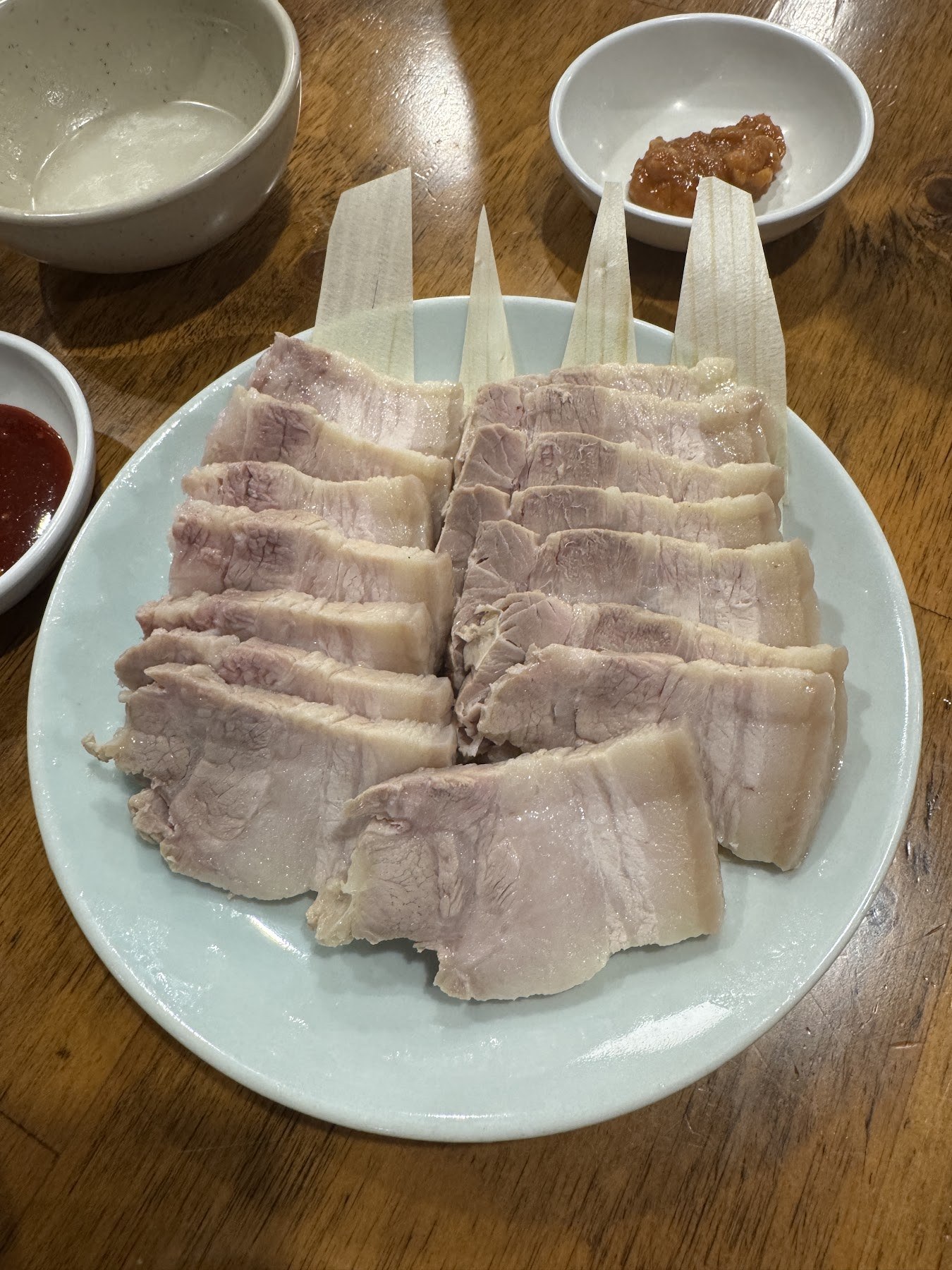 切成薄片、層層疊放在盤子上的水煮豬肉