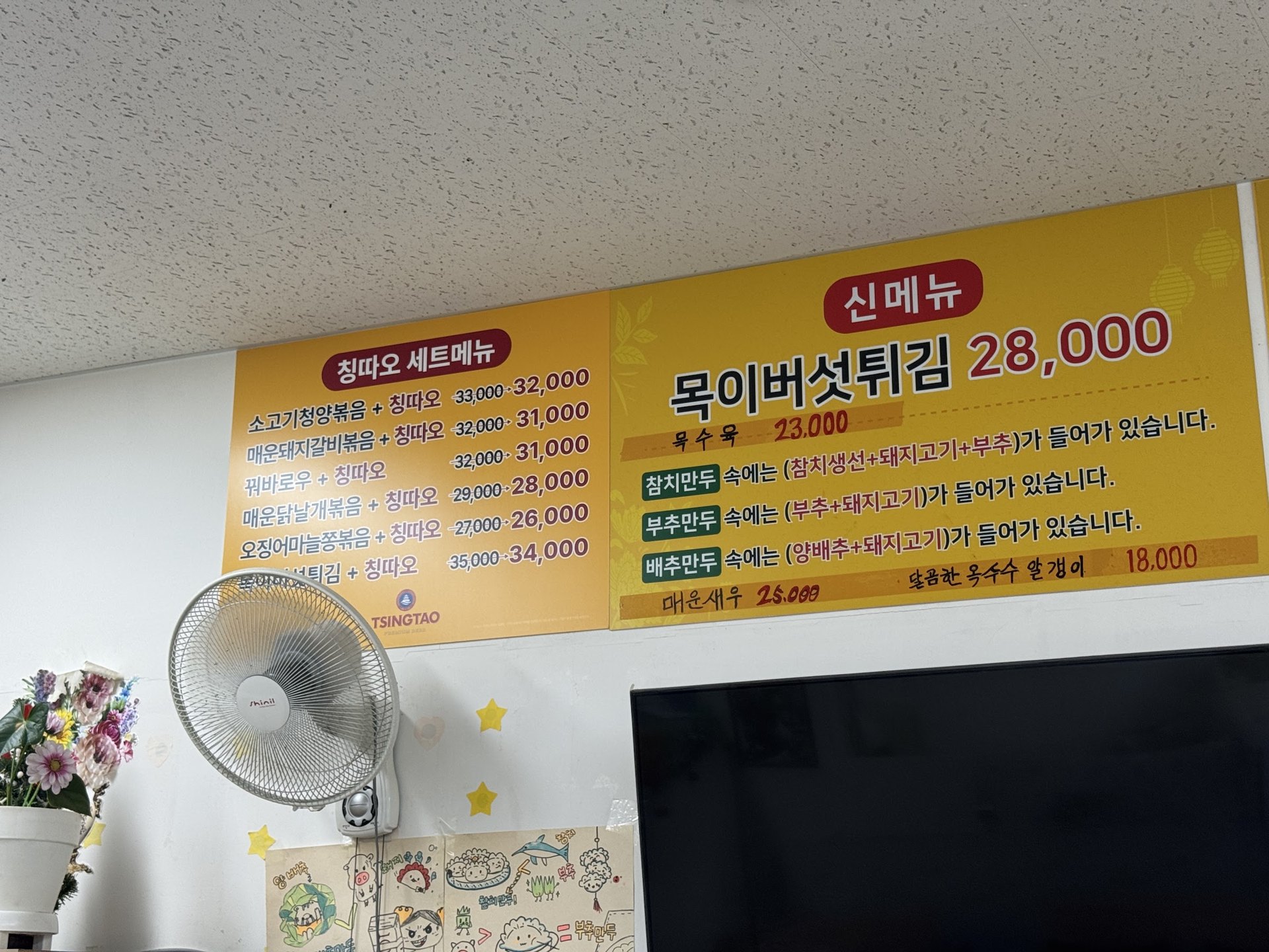 신메뉴와 칭따오 세트메뉴가 적힌 벽 배너
