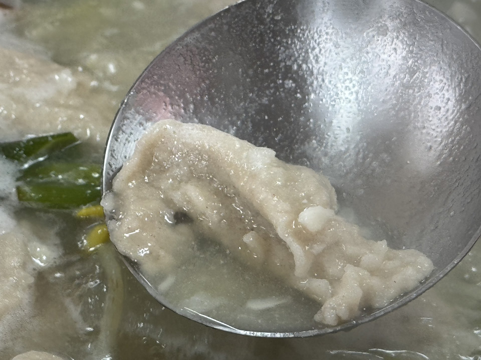 用湯勺撈起的一塊河豚肉