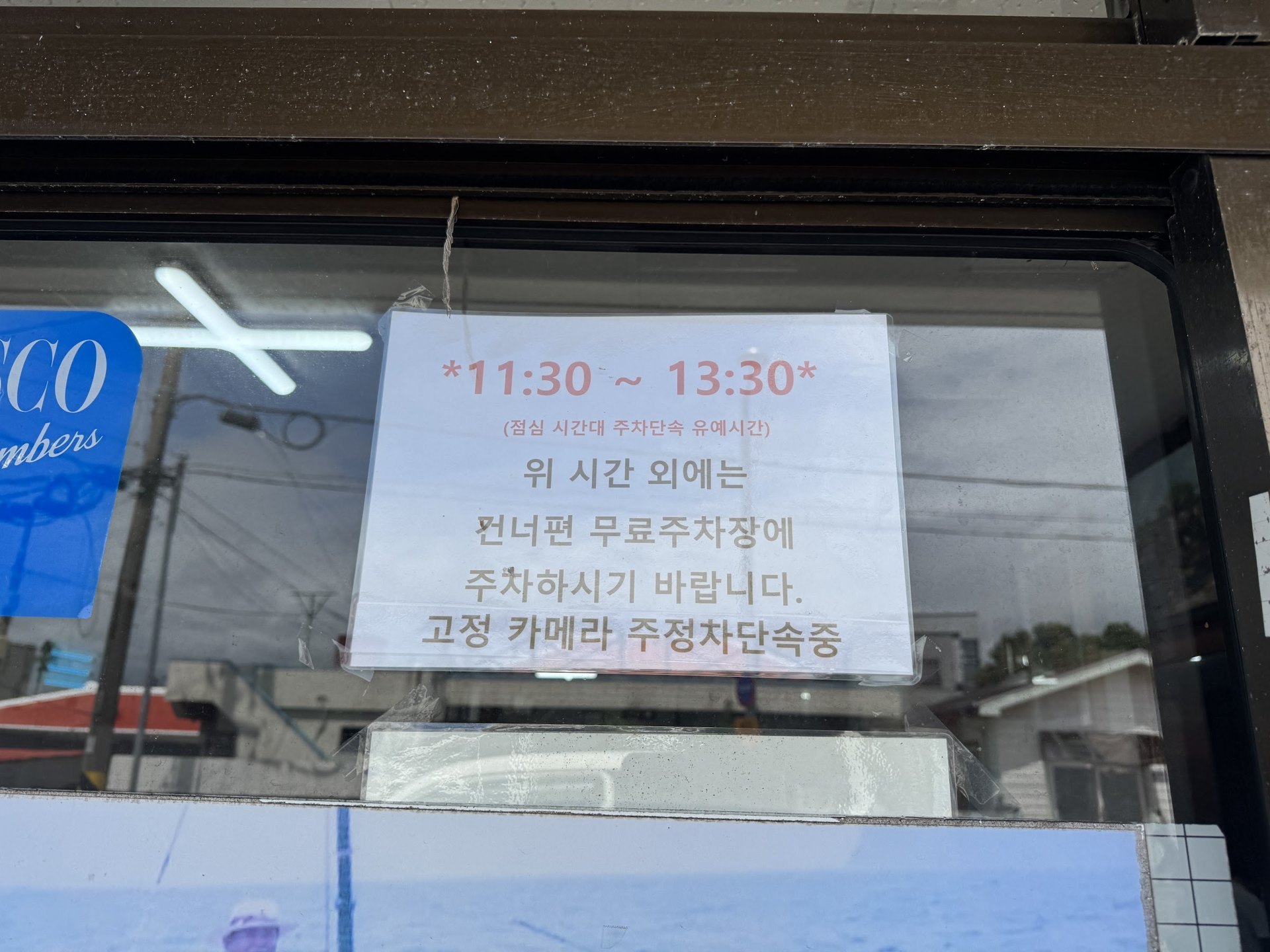 寫著停車說明並貼在玻璃門上的公告