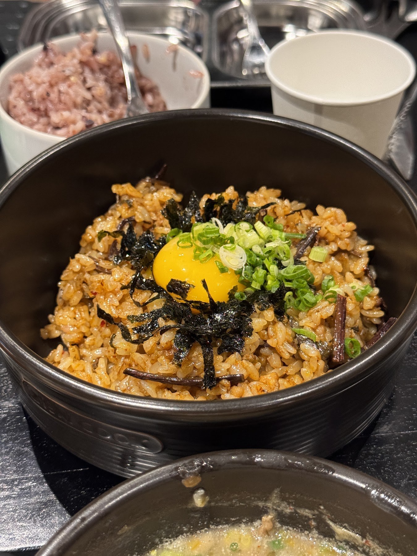 盛在石碗裡、放上蛋黃與海苔的炒飯