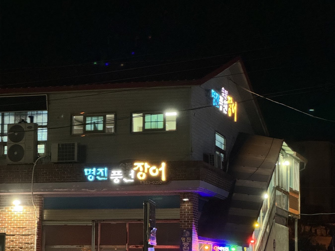 夜裡亮著燈的明進風川鰻魚建築外觀