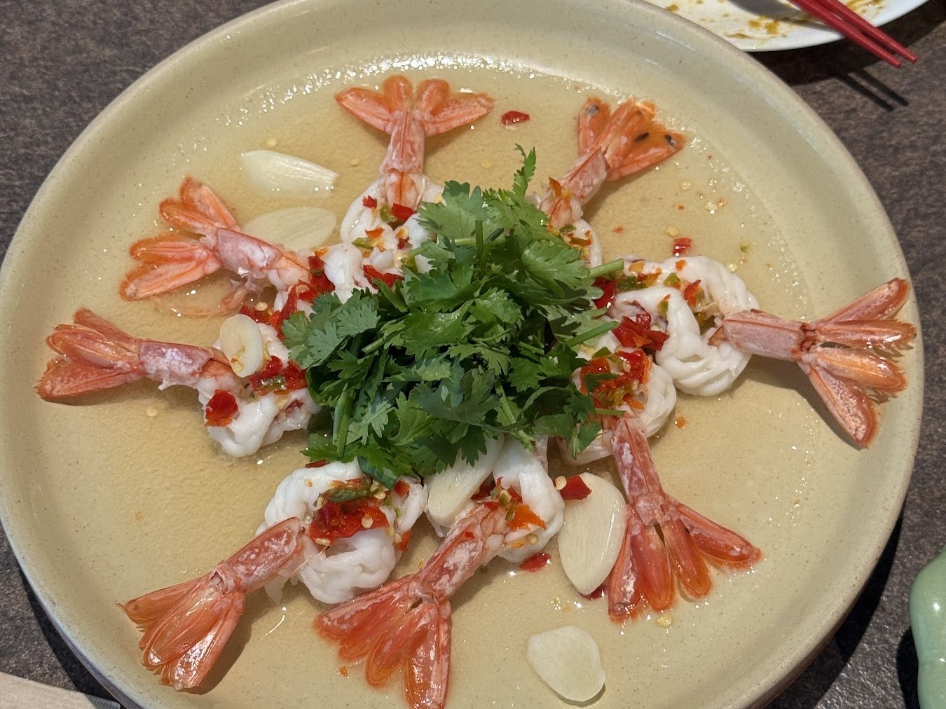 在盤上排成一圈、放上香菜的生蝦料理