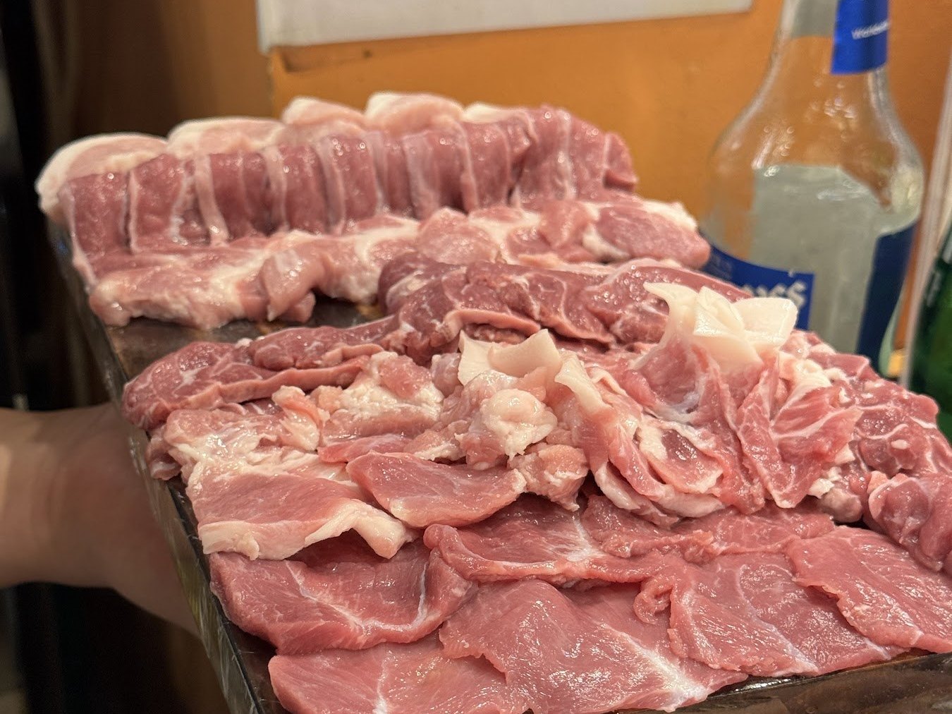 木砧板上依部位分層盛放的生肉