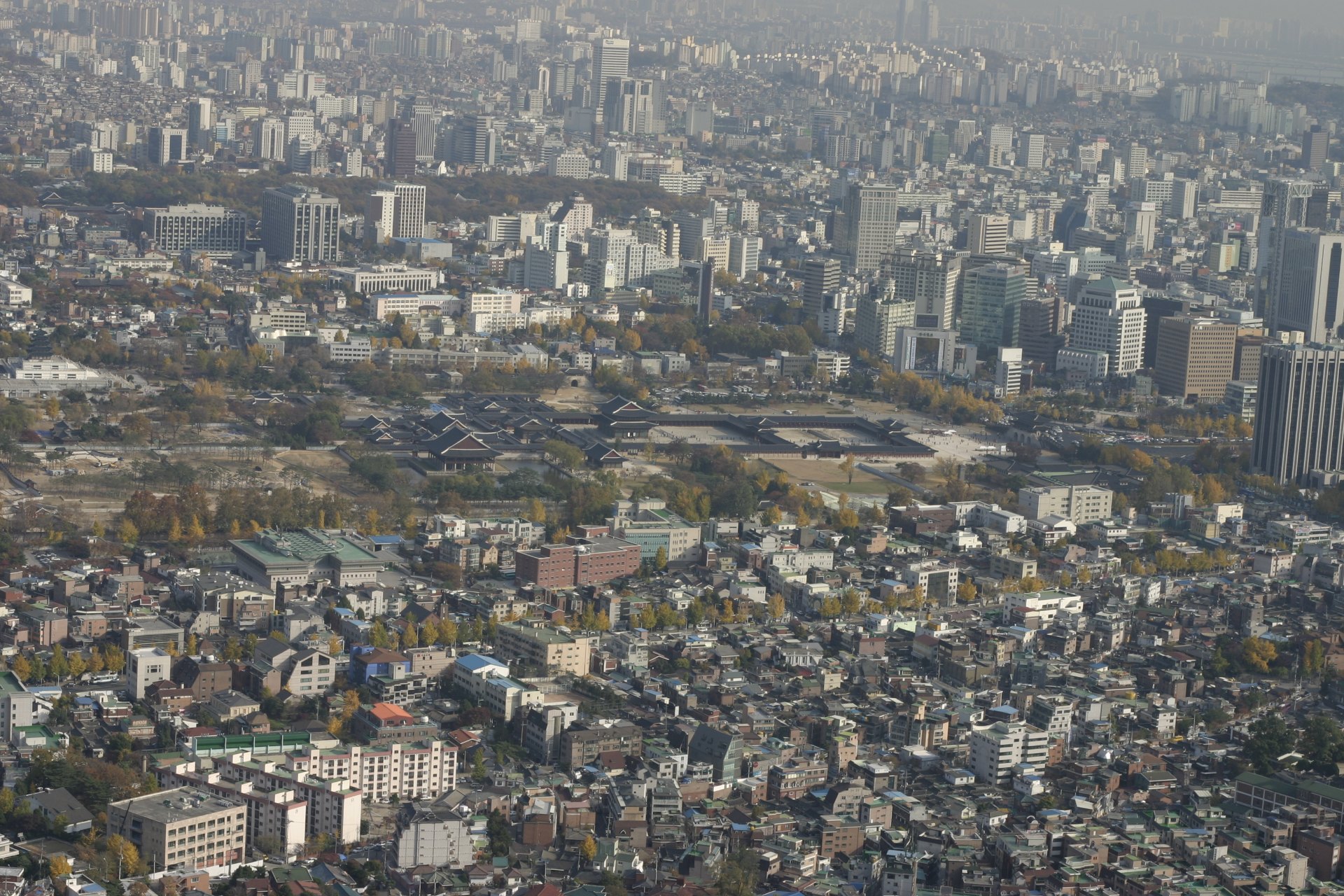 Pedestrians in winter coats on a Seoul street in November