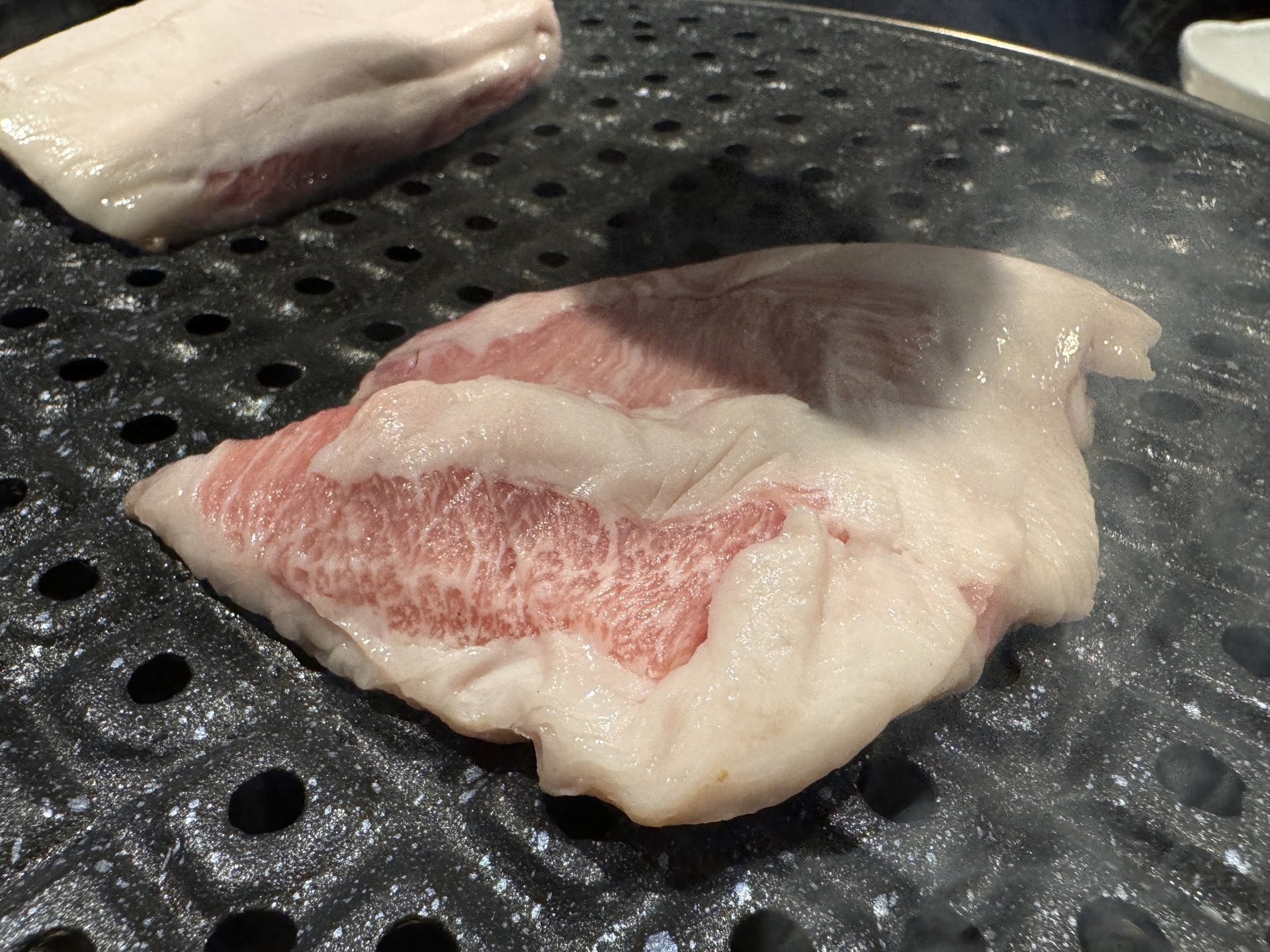 放在石板上的一大塊厚五花肉