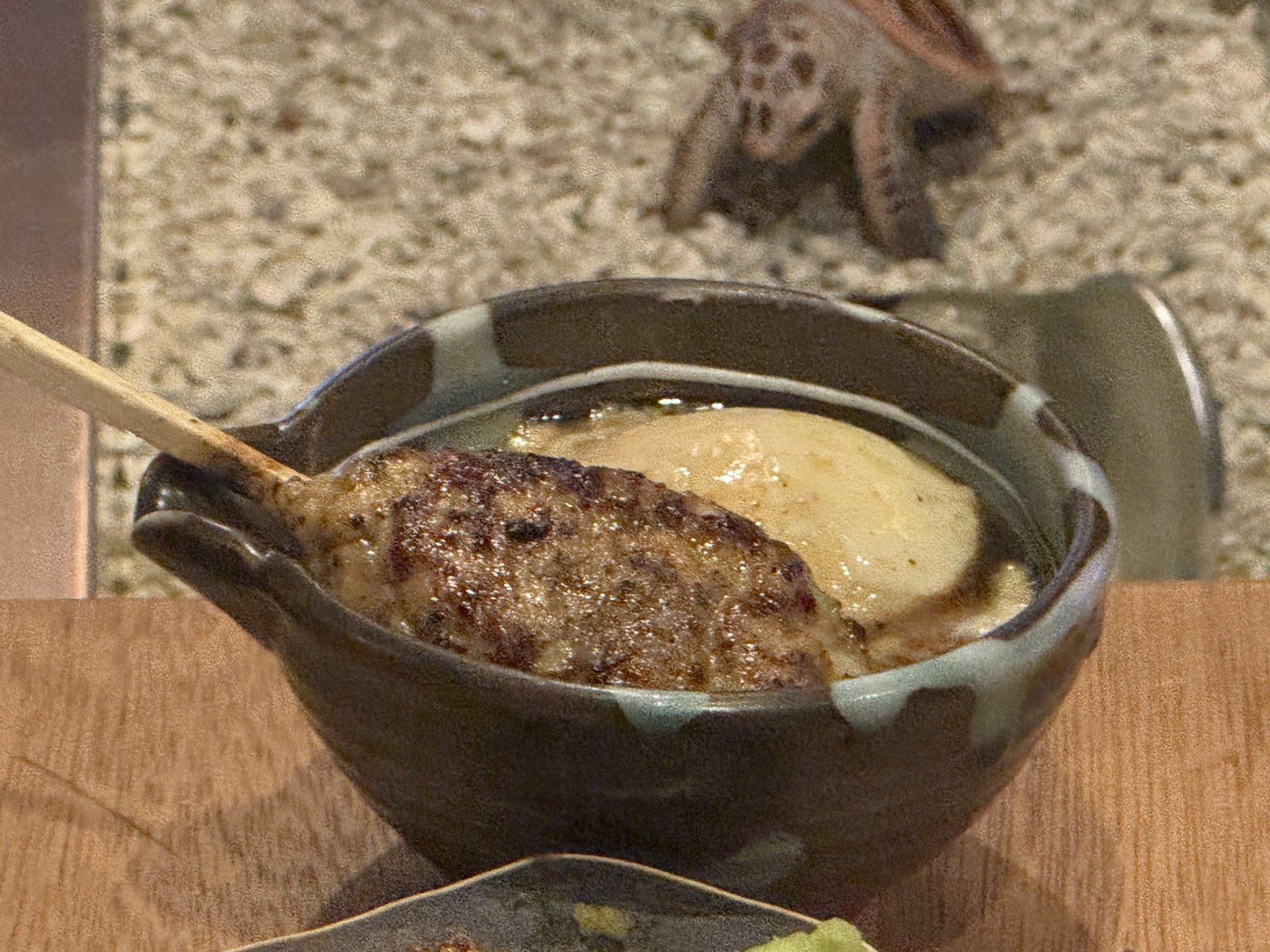 砂鍋中奶油色醬汁上放著的絞肉串
