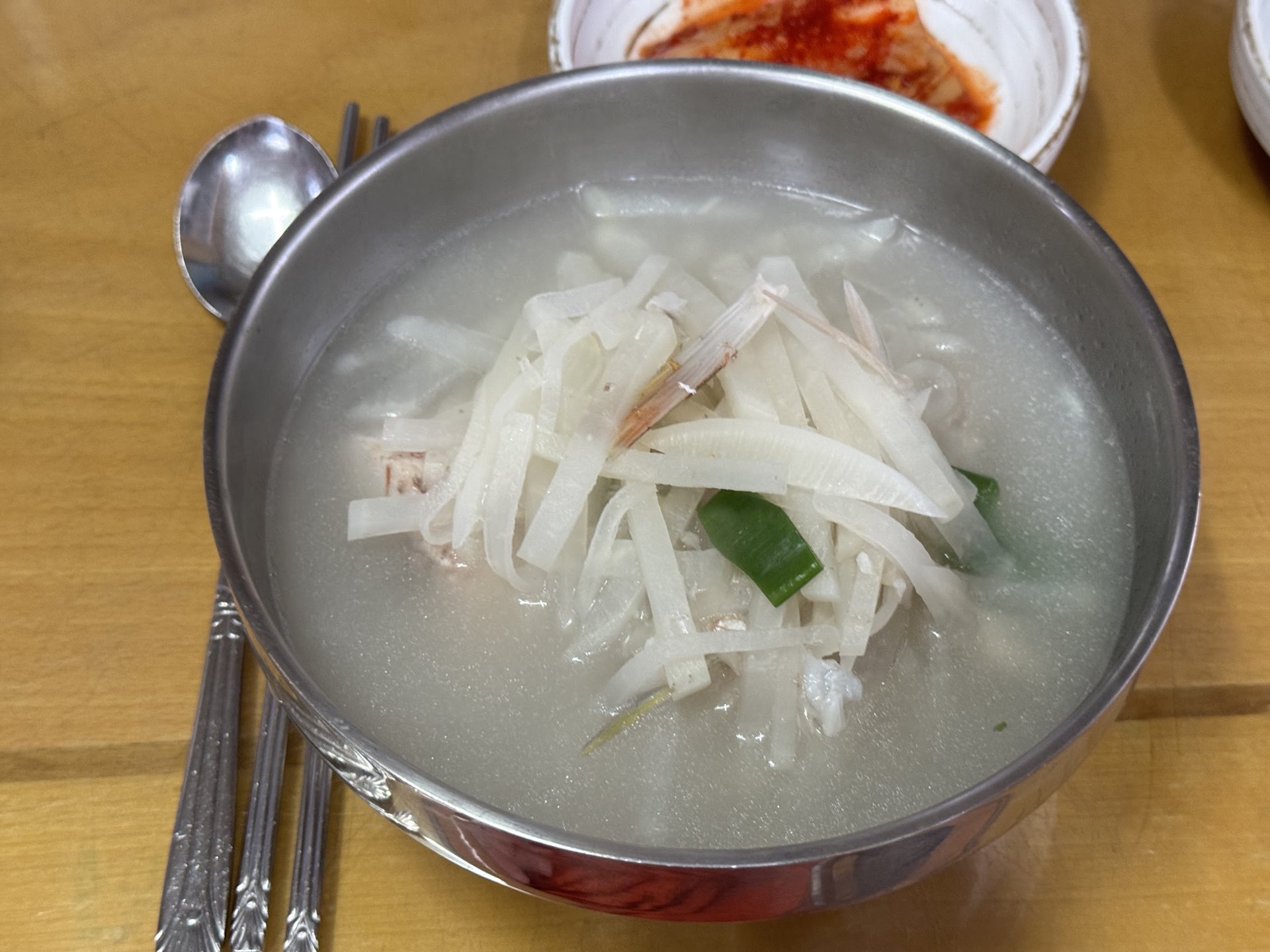 Clear fish soup under a heap of shredded radish