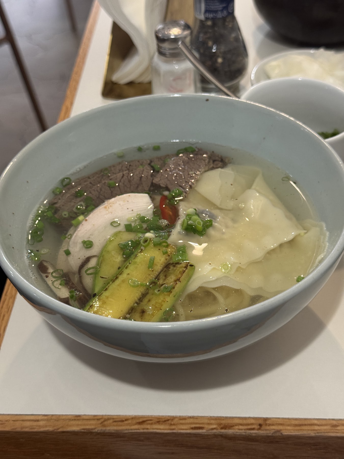 清湯裡浮著小黃瓜、肉片與白色餃子的一碗