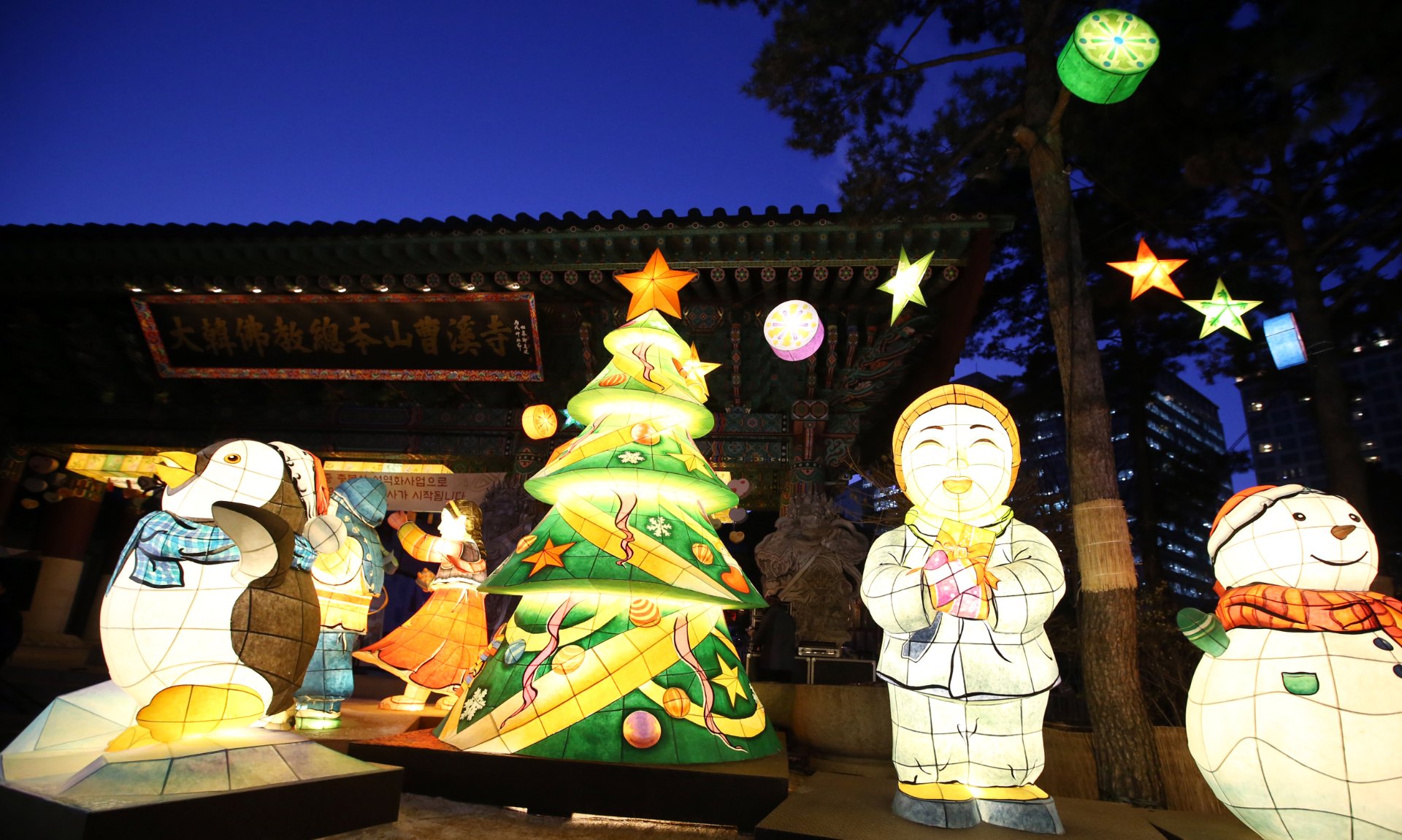 A Christmas tree and lanterns lit up in the grounds of Jogyesa temple