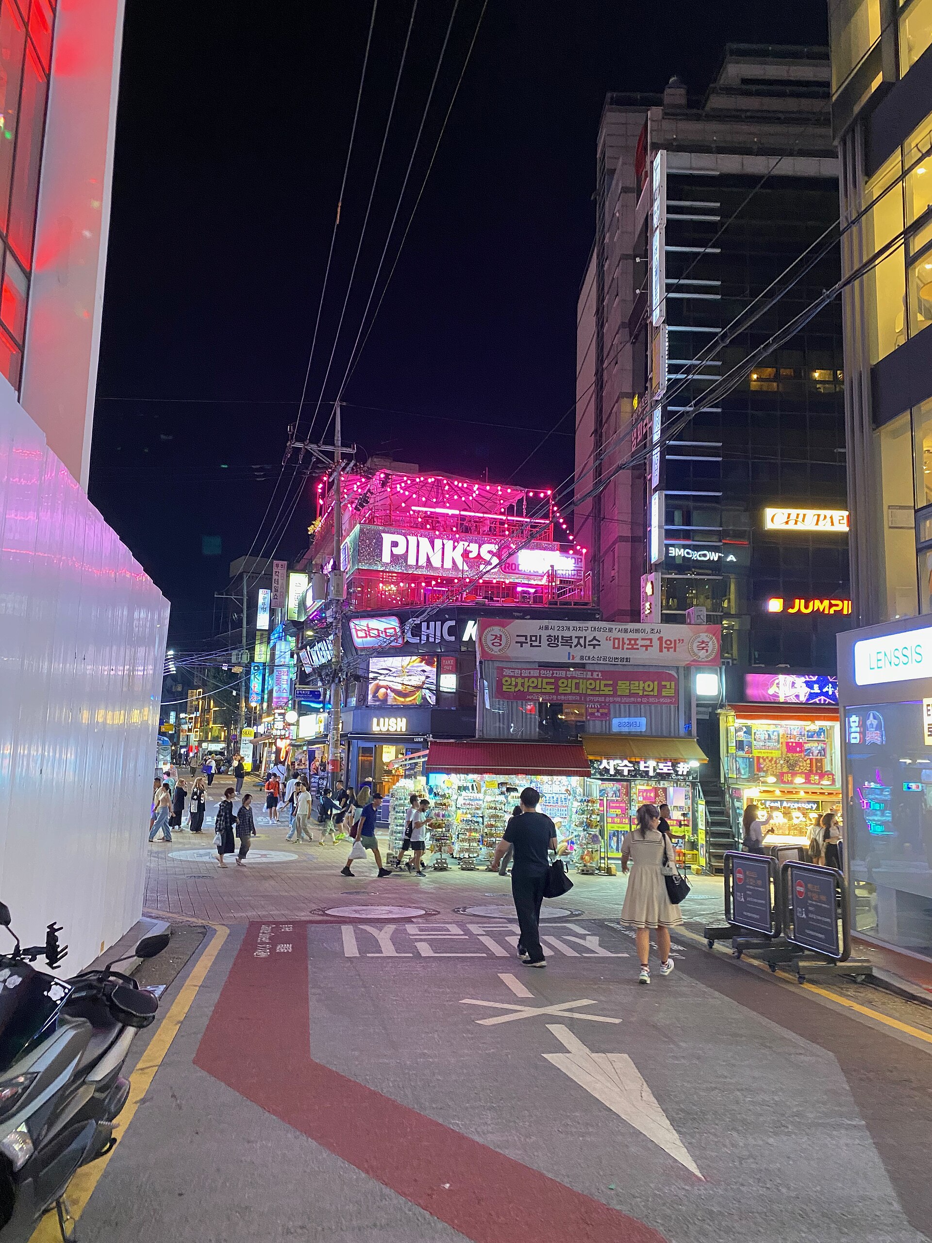 A Hongdae street at night with neon signs
