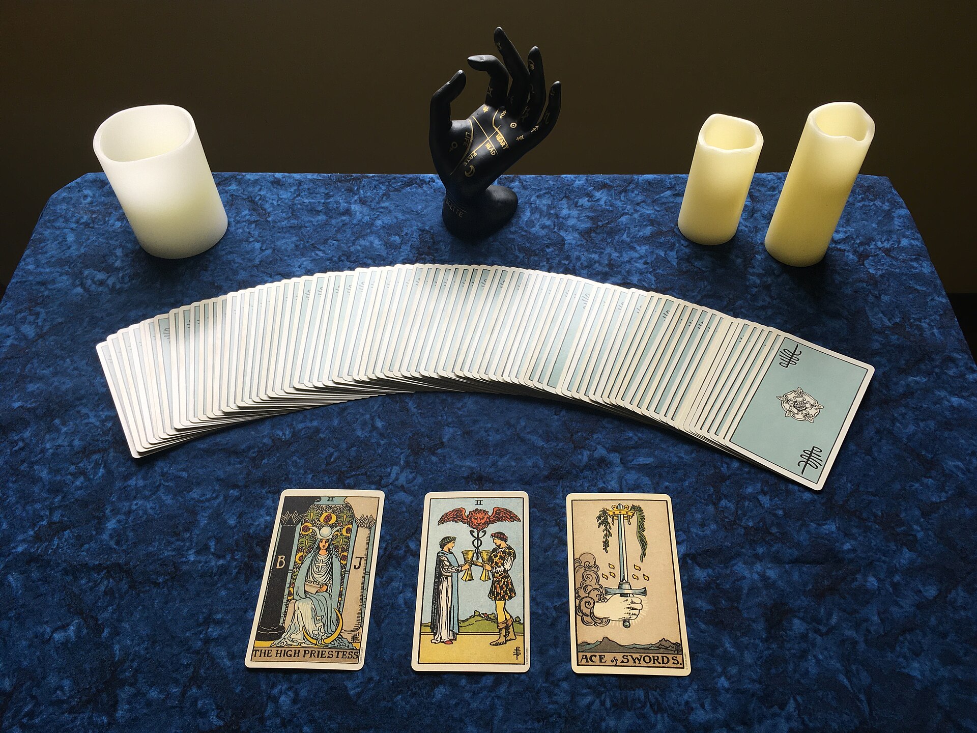 A three-card tarot spread with candles
