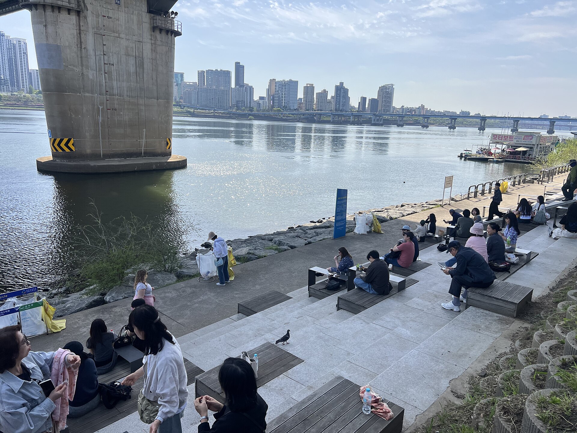 People sitting along the river at Ttukseom Hangang Park