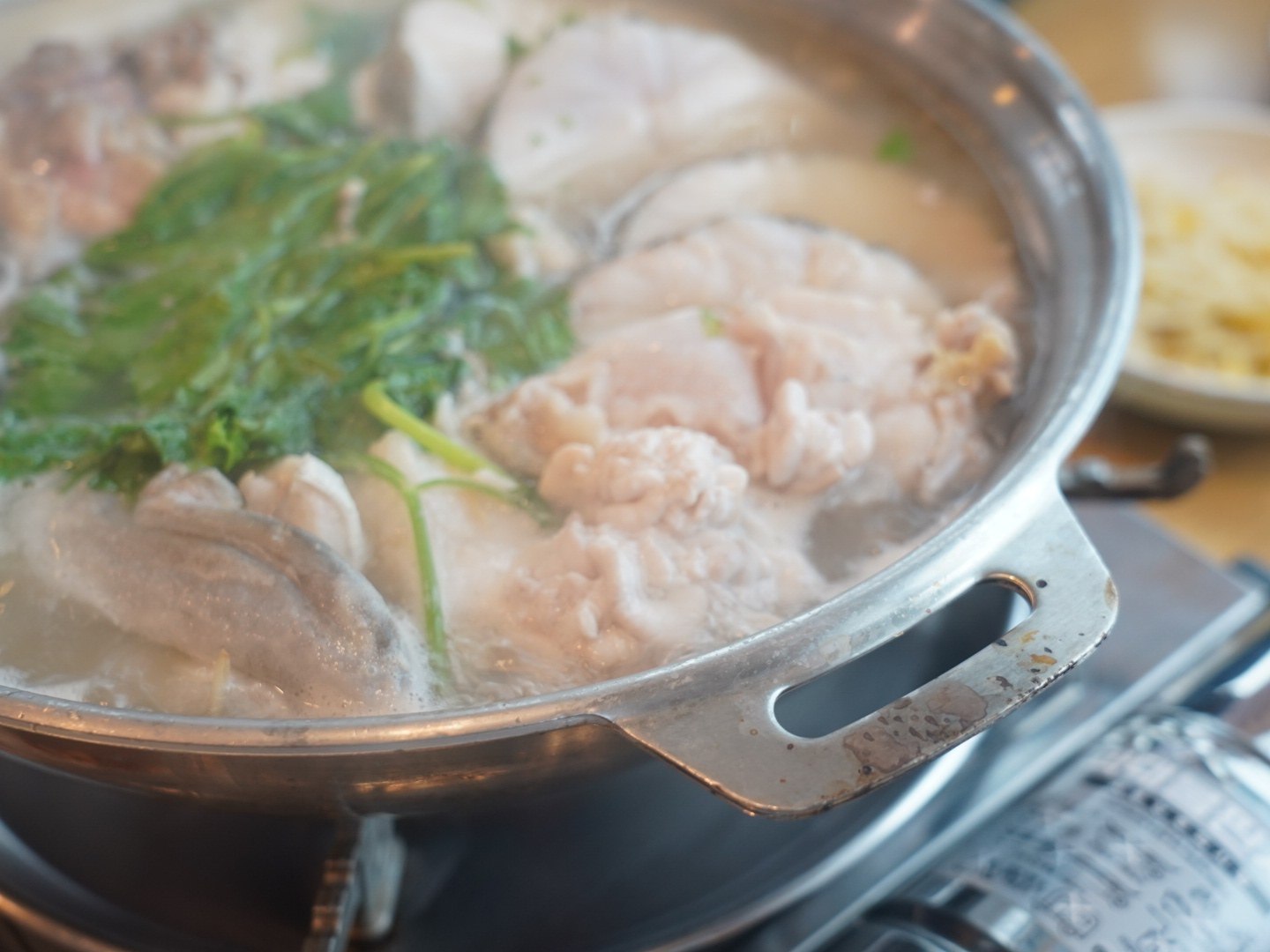 在湯裡慢慢煮熟的厚實鱈魚肉