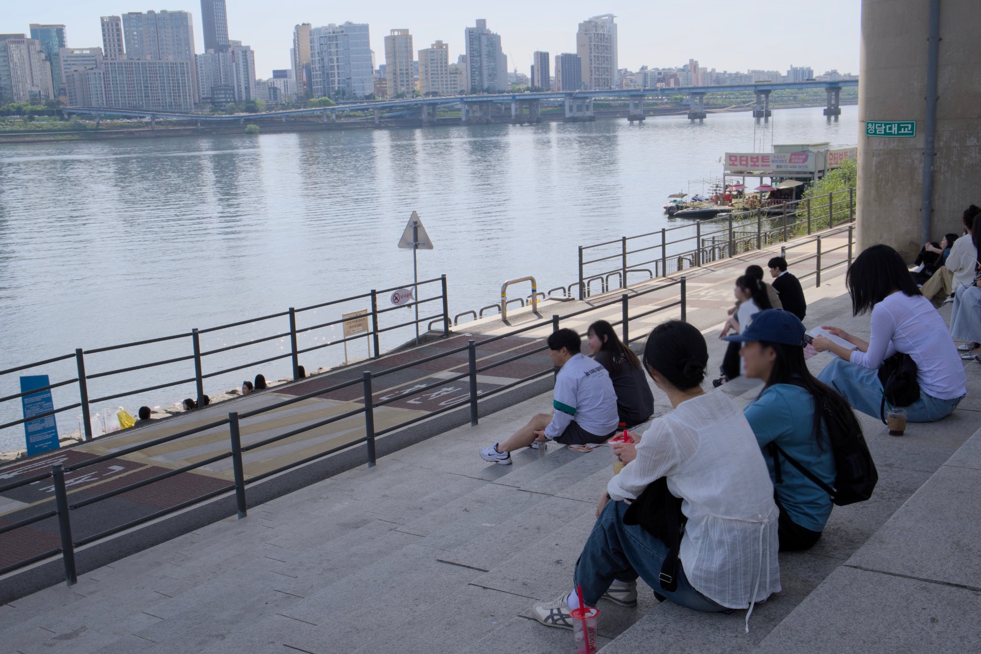 People sitting by the river at Ttukseom Hangang Park