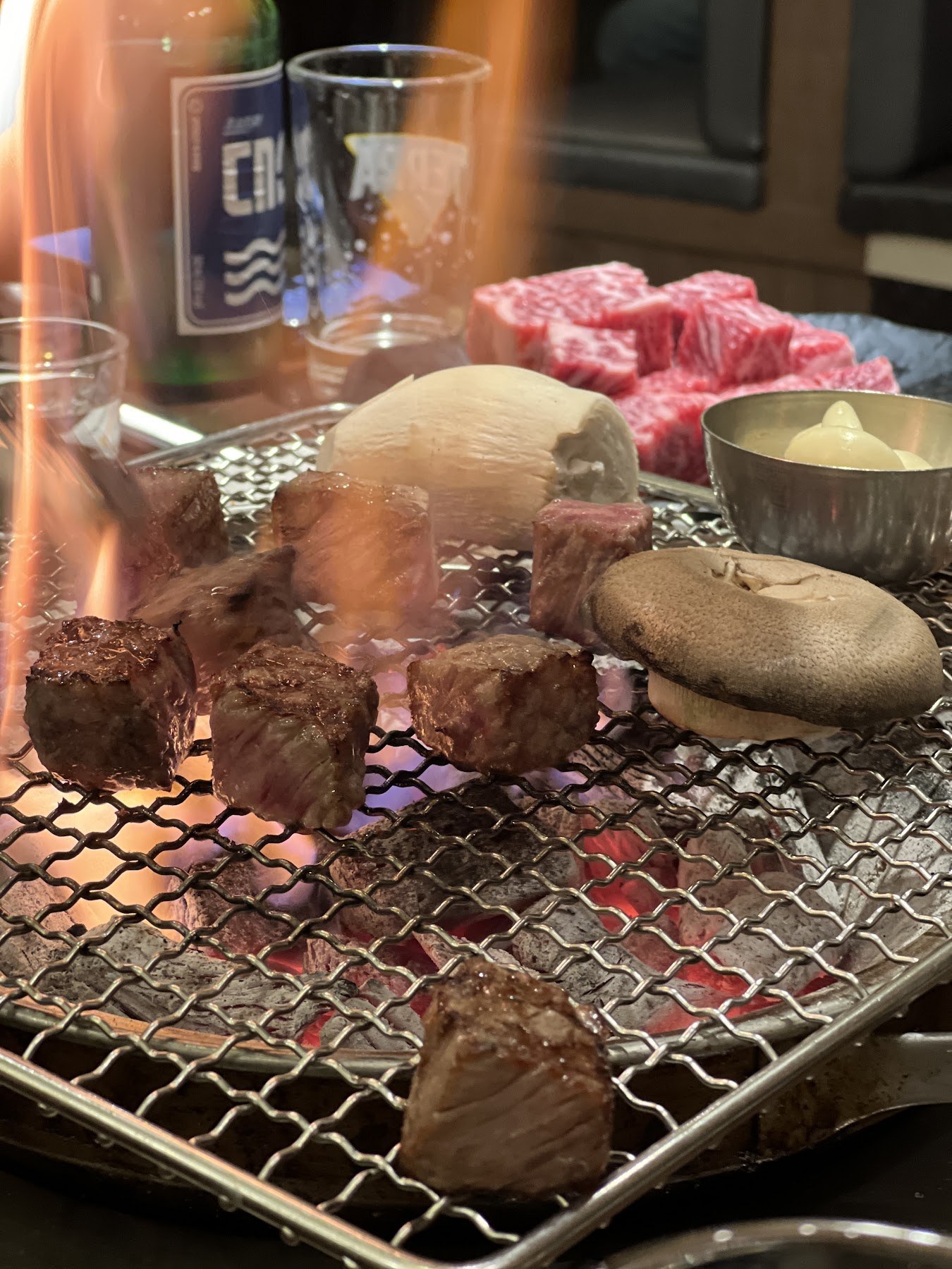 Flames rising from the charcoal under the grill rack